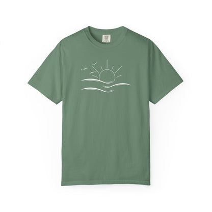 an oversized green t-shirt the image on the front is a simple line drawing of waves and a sun with birds flying around the sun.