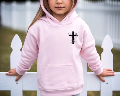A light pink youth hoodie with a spray painted Jesus cross on the left chest if the sweater.