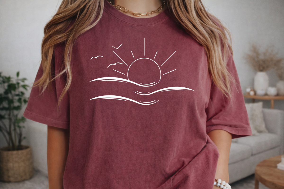 an oversized crimson t-shirt the image on the front is a simple line drawing of waves and a sun with birds flying around the sun.