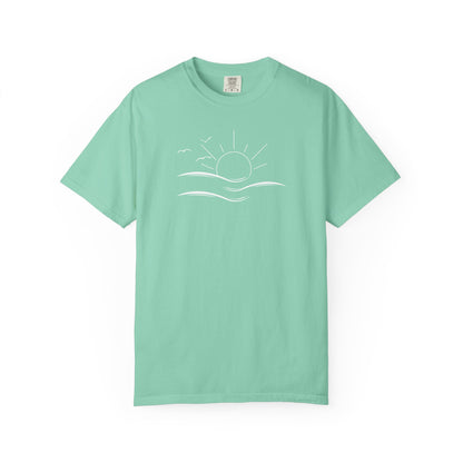 an oversized green t-shirt the image on the front is a simple line drawing of waves and a sun with birds flying around the sun.
