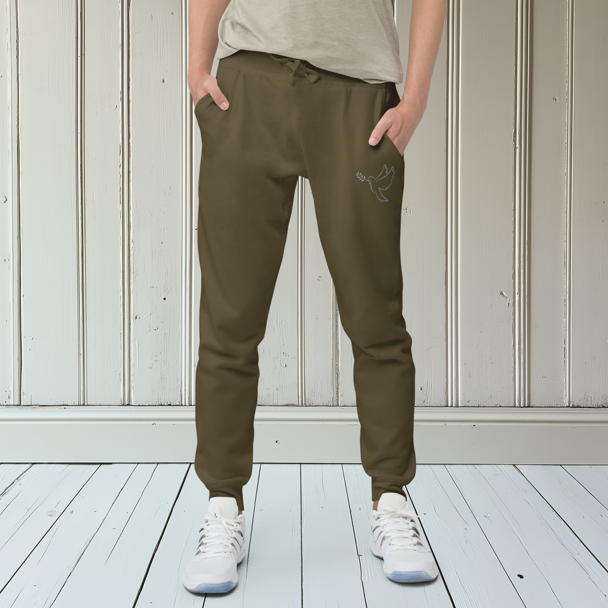 A pair of fleece lined mid rise skinny leg sweatpants with an embroidered silver dove carrying a fig leaf over the left front pocket of the pants.