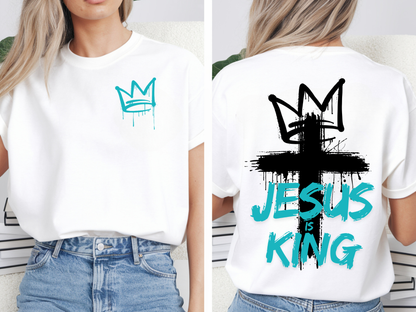 A oversized graphic t-shirt with an image of a crown spray painted on the top right chest of the shirt, on the back of the shirt is a large cross spray painted on the back with a cross on the top with the words 'Jesus is King' spray painted on the top.