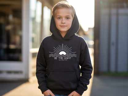 A black youth hoodie with an image of the sun and waves underneath with the words Be the Light Matthew 5:14 