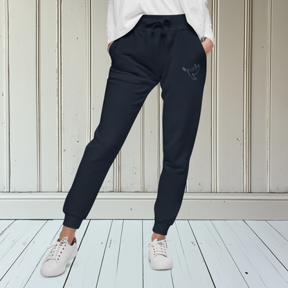 A pair of fleece lined mid rise skinny leg sweatpants with an embroidered silver dove carrying a fig leaf over the left front pocket of the pants.