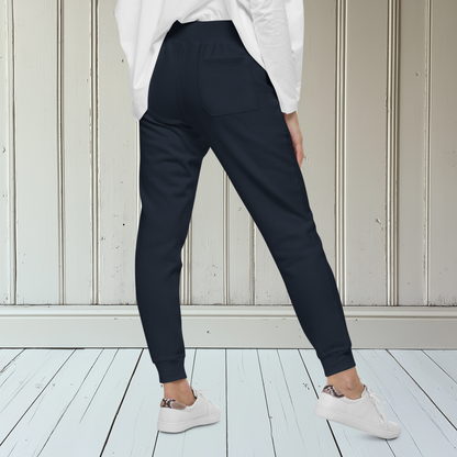 A pair of fleece lined mid rise skinny leg sweatpants with an embroidered silver dove carrying a fig leaf over the left front pocket of the pants.