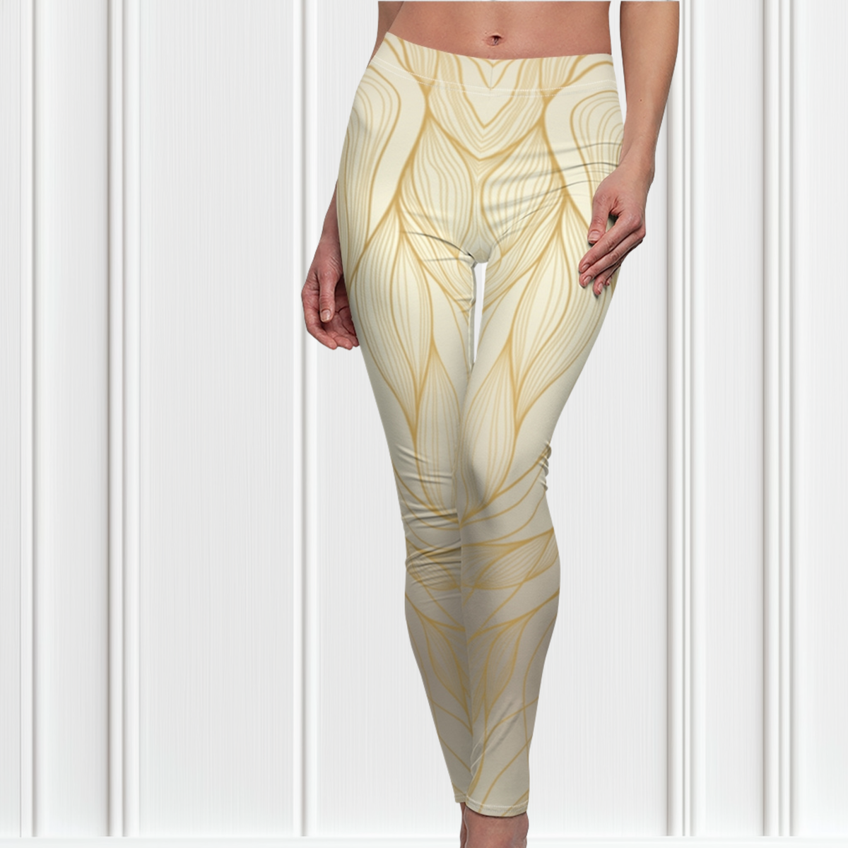 A pair of women's high waisted leggings, they are beige in color with abstract gold lines all over the pants.