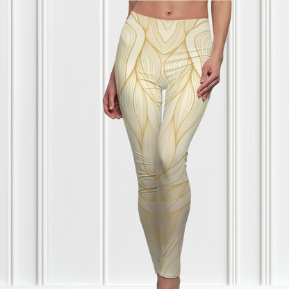 A pair of women's high waisted leggings, they are beige in color with abstract gold lines all over the pants.