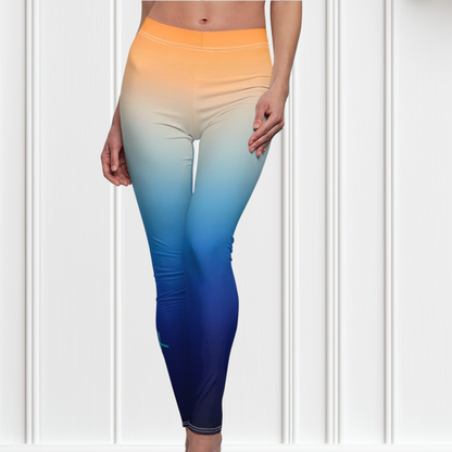 A pair of high waisted ombre leggings that start as a light orange then fade to a dark blue at the bottom, there is a light blue Jesus cross on the right ankle of the pants.