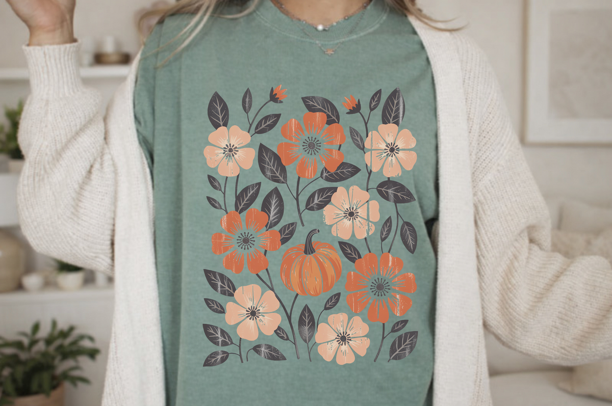 A graphic t-shirt with flowers and pumpkins all over the shirt, perfect for fall time.