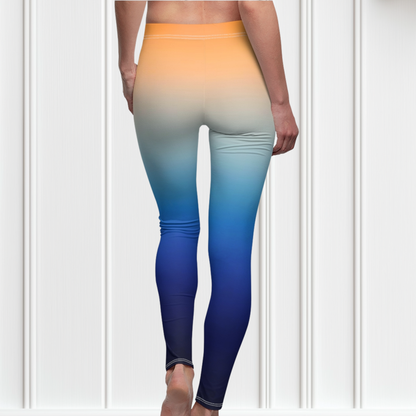 A pair of high waisted ombre leggings that start as a light orange then fade to a dark blue at the bottom, there is a light blue Jesus cross on the right ankle of the pants.