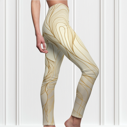 A pair of women's high waisted leggings, they are beige in color with abstract gold lines all over the pants.