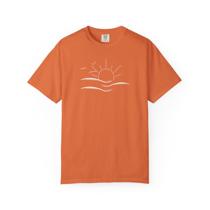 an oversized orange t-shirt the image on the front is a simple line drawing of waves and a sun with birds flying around the sun.