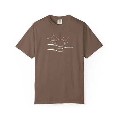 an oversized brown t-shirt the image on the front is a simple line drawing of waves and a sun with birds flying around the sun.