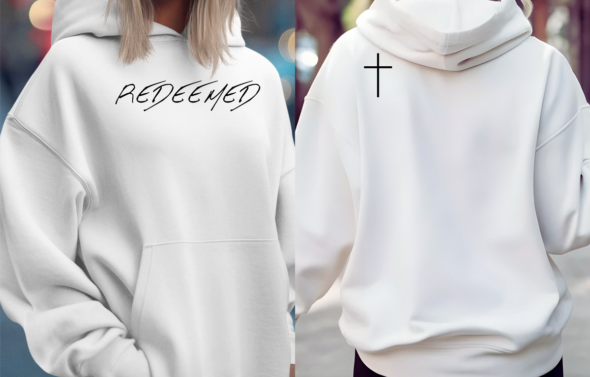 A white hoodie with the words redeemed on the front center, a Jesus cross is on the back left shoulder of the hoodie.
