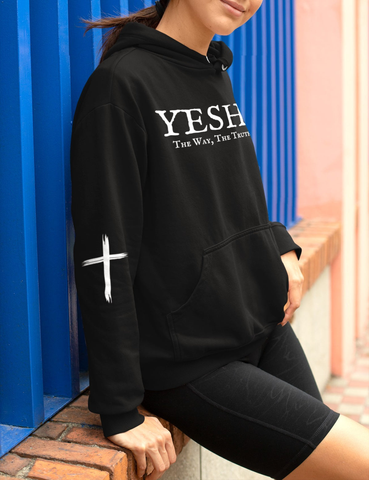 On the front of this Christian hoodie are the words 'Yeshua the way the truth the life' there is a Jesus cross on both sleeves of the hoodie.