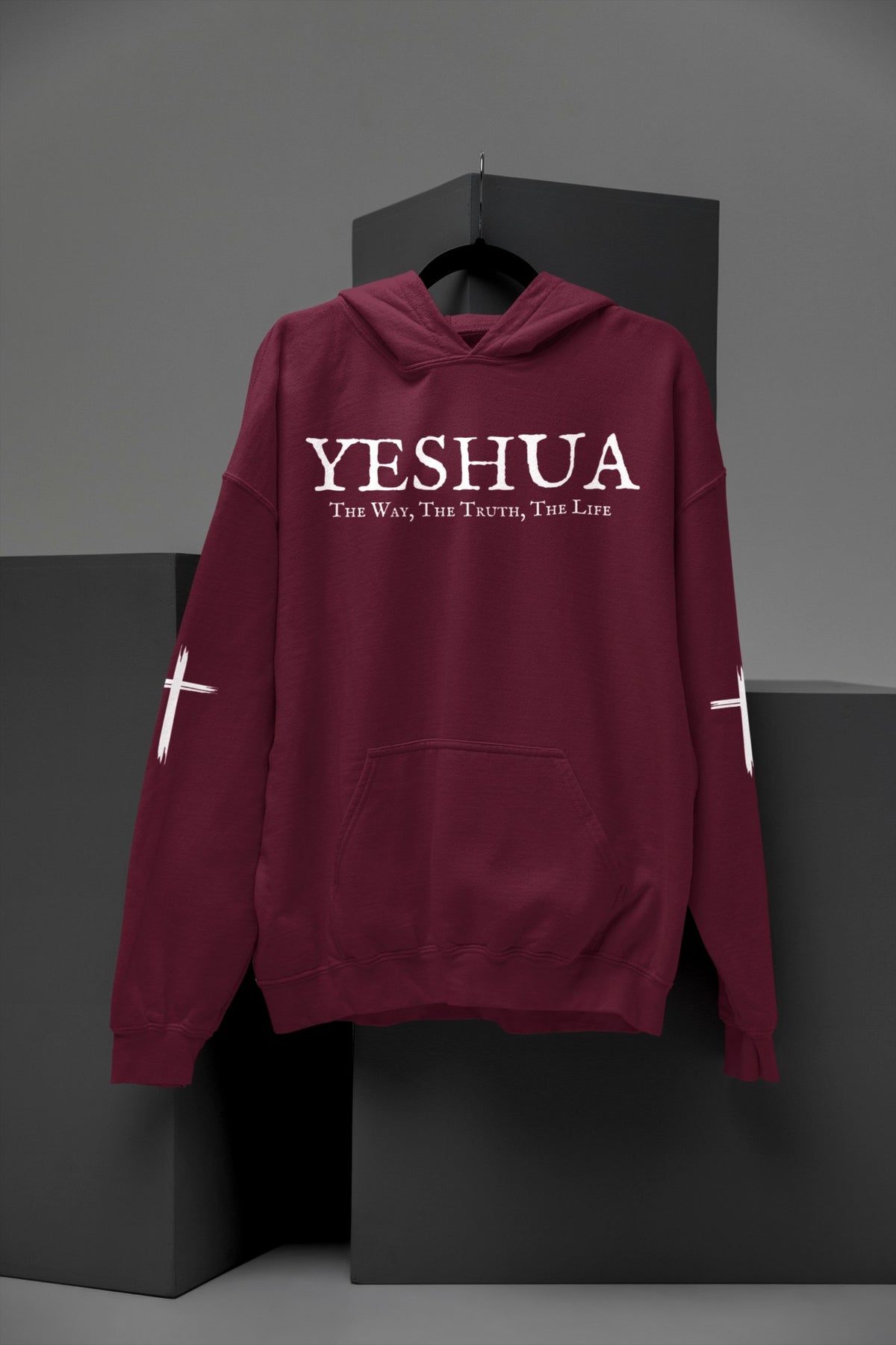 On the front of this Christian hoodie are the words 'Yeshua the way the truth the life' there is a Jesus cross on both sleeves of the hoodie.