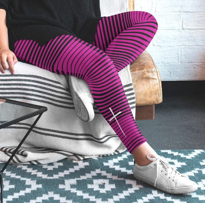 A woman wearing hot pink with black stripes high waisted leggings with a white Jesus cross on the right ankle of the pants.