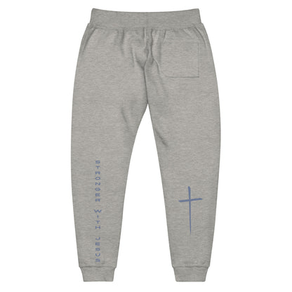 A pair of fleece lined sweatpants that have the words Stronger With Jesus on the back left leg of the pants, on the right leg is a large Jesus cross